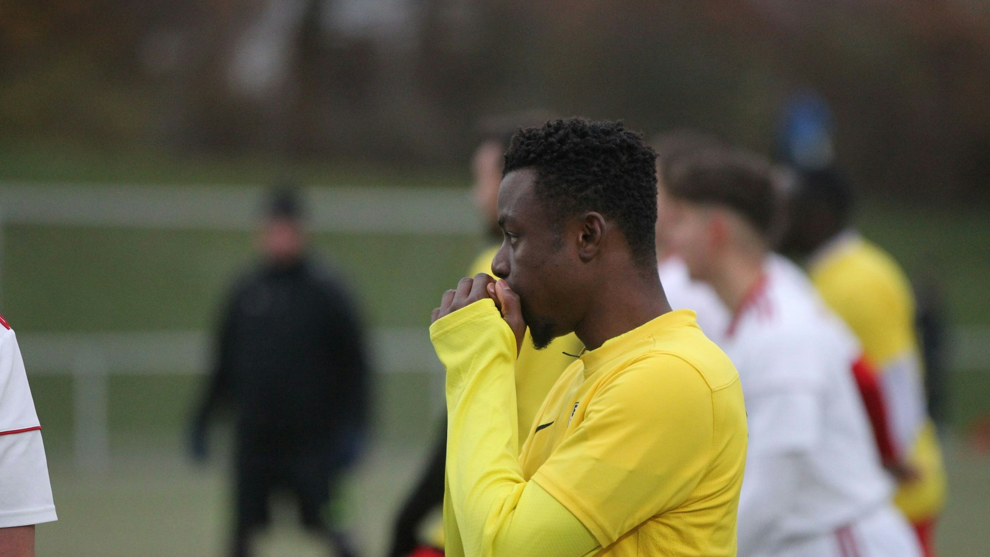 Ein Spieler des Euskirchener TSC pustet in seine Hände. Es ist kalt auf dem Fußballplatz in Euskirchen.