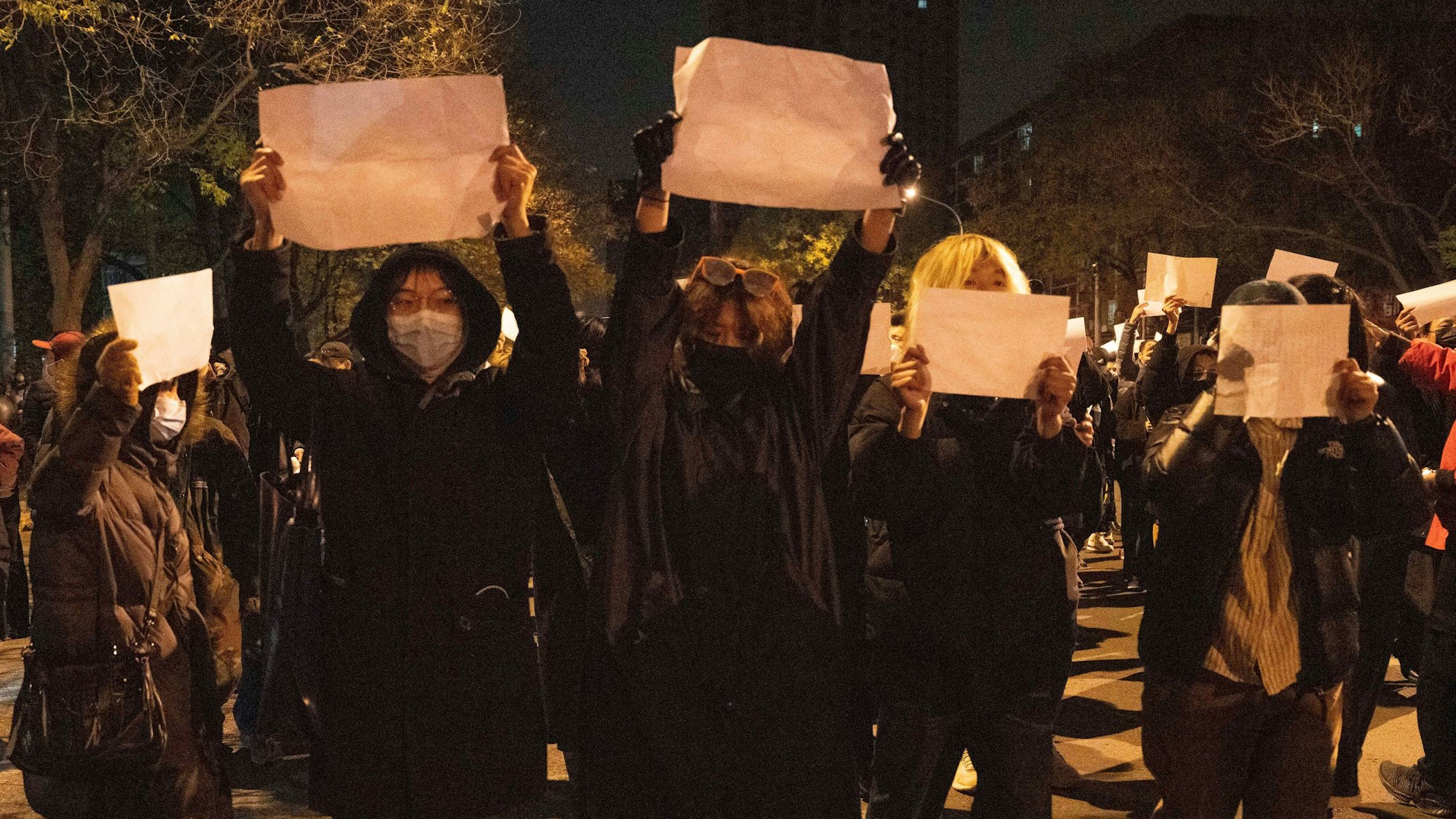 Demonstranten in Peking halten leere Zettel in die Höhe.