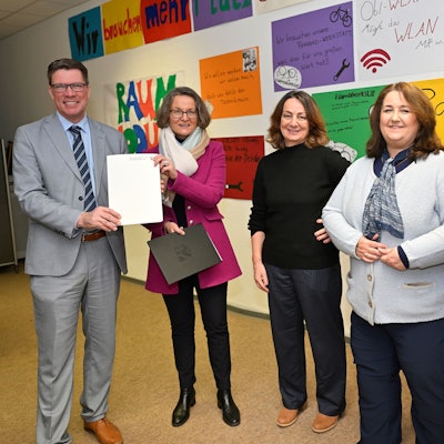 Ministerin Ina Scharrenbach übergibt Rhein-Bergs Landrat Stephan Santelmann einen Bescheid über Wiederaufbaumittel in der Albert-Einstein-Schule.