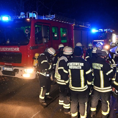 Rösrather Feuerwehrleute stehen bei Nacht vor einem Einsatzfahrzeug.