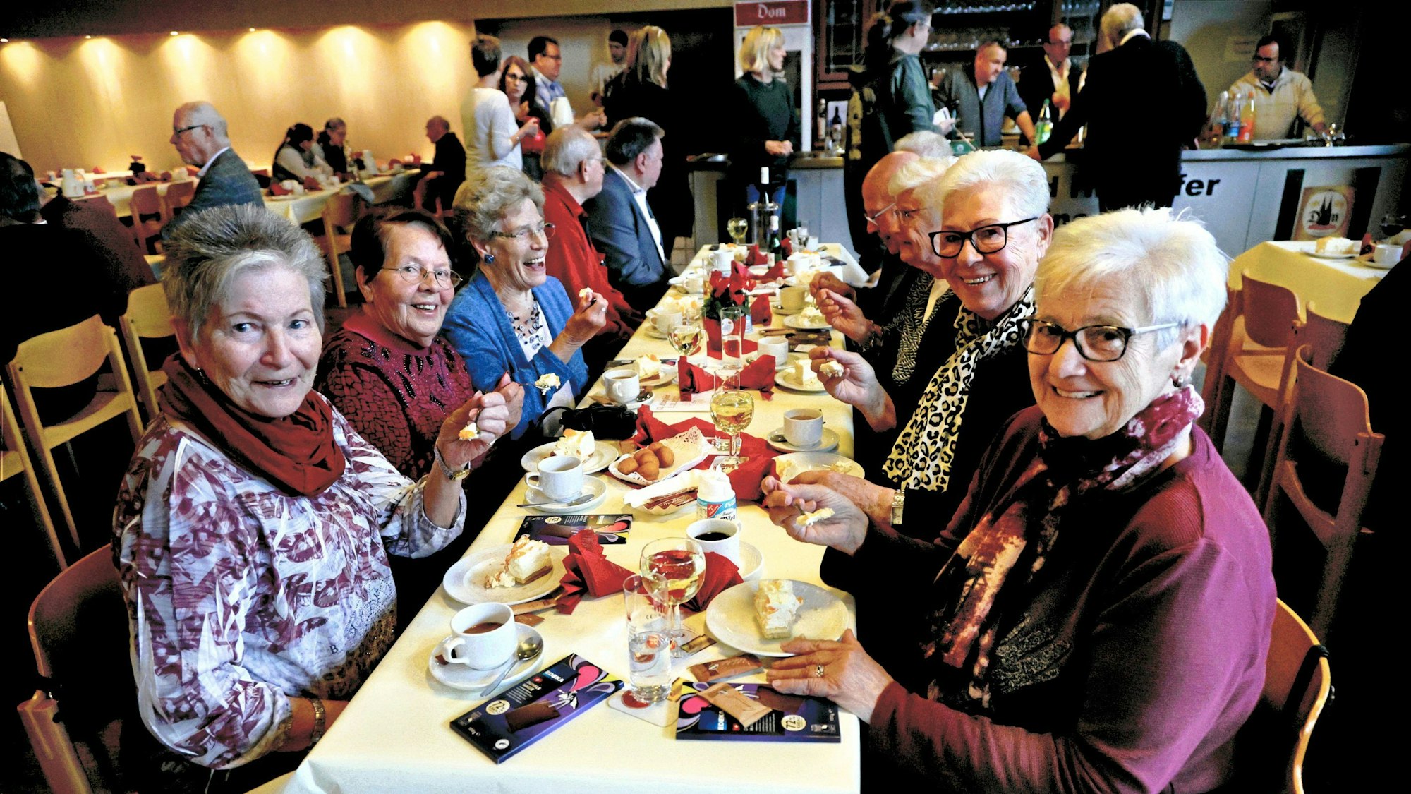 Senioren sitzen an einem Tisch mit Kaffee und Kuchen bei der Leverkusener Altenfeier in der Stadthalle Hitdorf.
