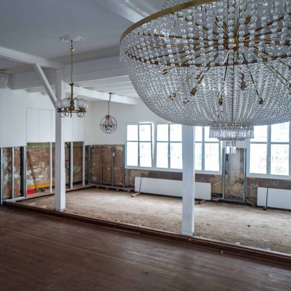 Im Saal des Brauhauses sind die Schäden, die die Flut verursacht hat, noch gut sichtbar. Im Vordergrund hängt ein Leuchter, im Hintergrund sind die Wände nach der Flut immer noch aufgerissen.