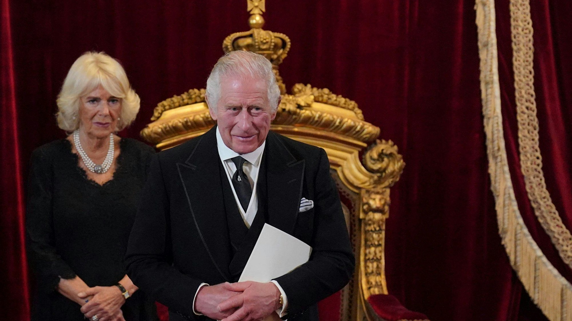 König Charles III. und Königsgemahlin Camilla vor einem goldenen Thron.
