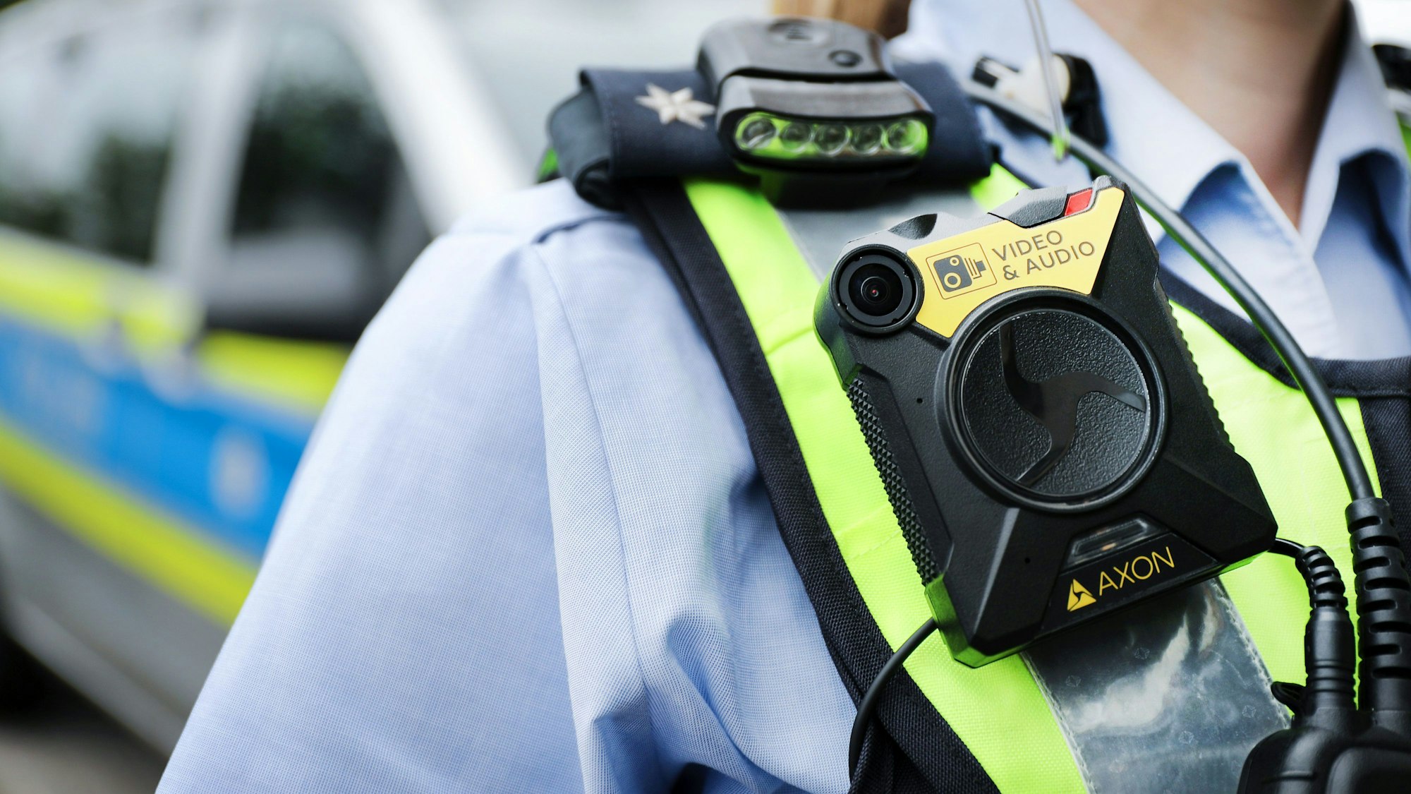 Eine Polizistin der Streifenpolizei führt eine Bodycam vor.