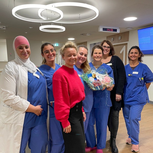 Hebammen und Ärztinnen mit einem Geschenk