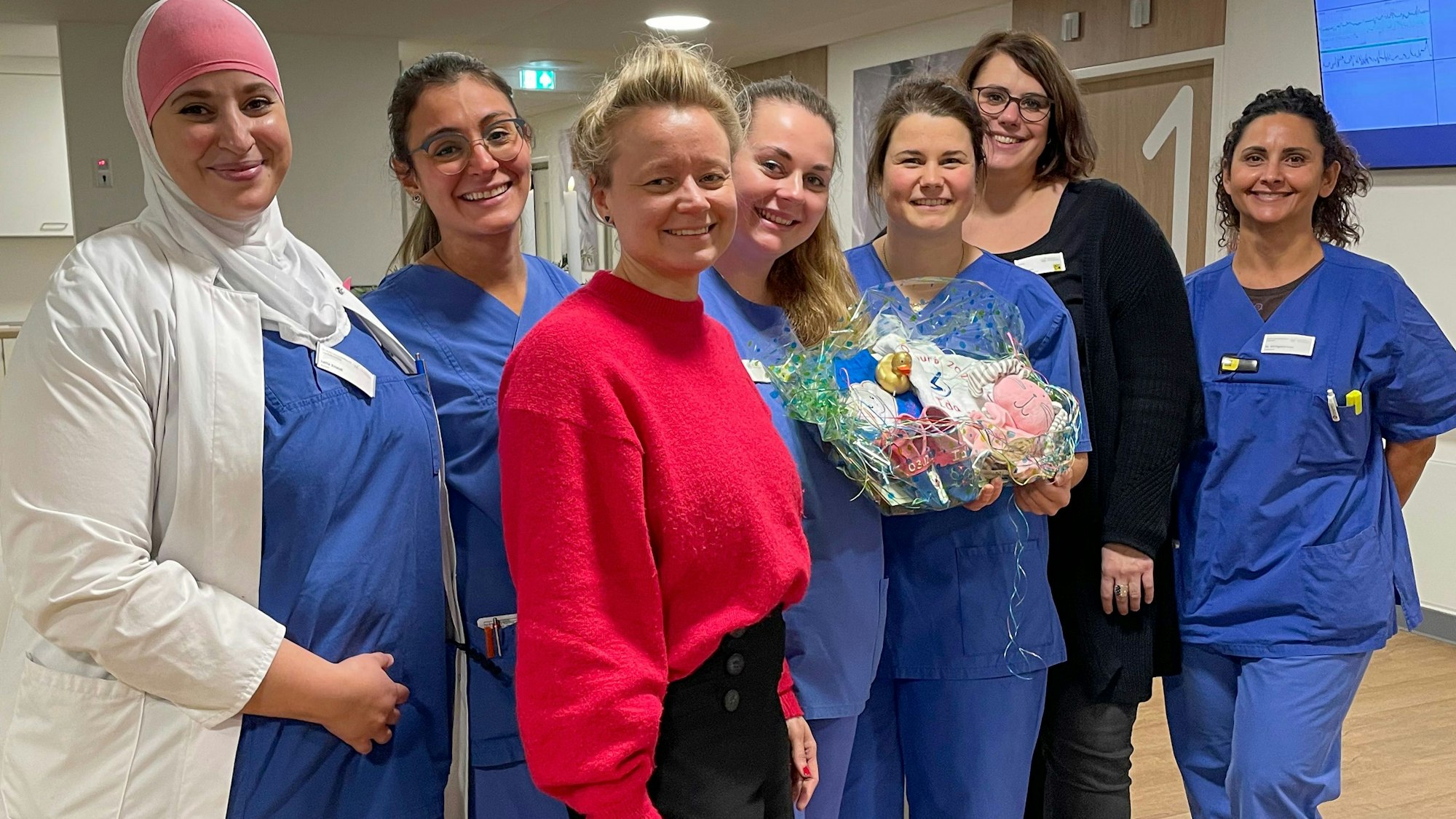 Hebammen und Ärztinnen mit einem Geschenk