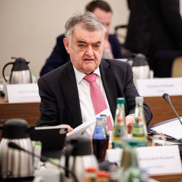 NRW-Innenminister Herbert Reul sitzt im Anzug bei einer Konferenz.