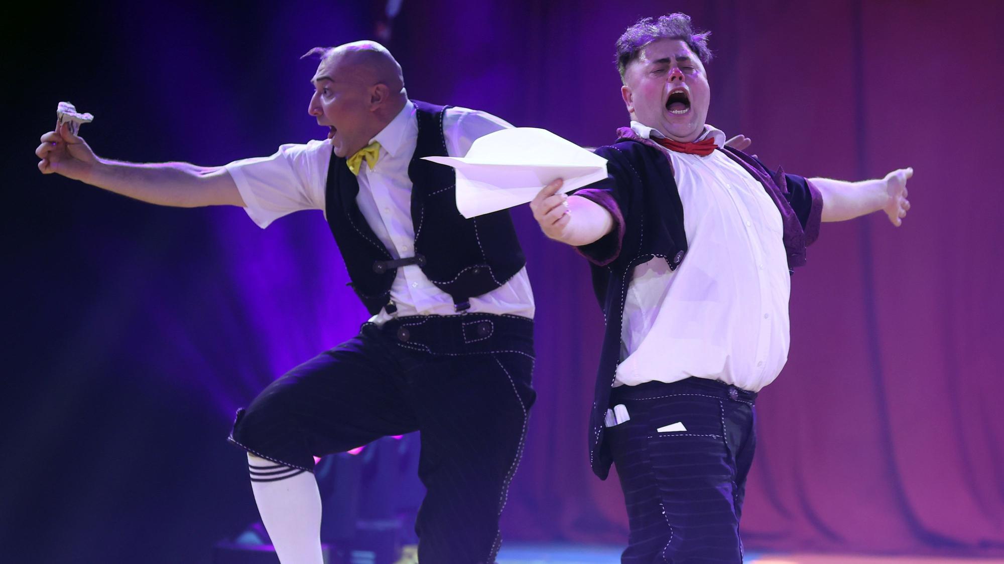 Zwei Clowns vom ukrainischen Trio Equivokee Clowns schneiden Grimassen beim Spielen mit Papierfliegern.