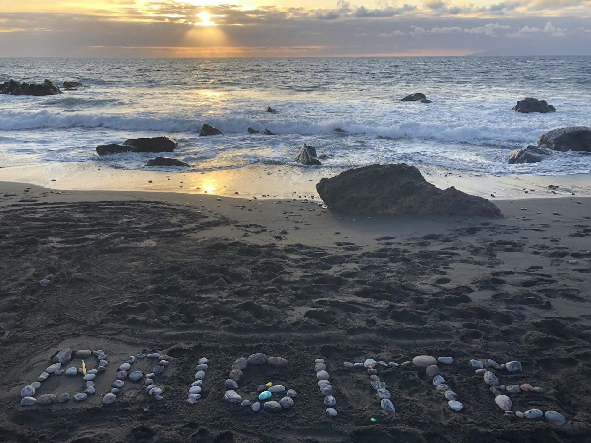 Freundinnen aus der Malgruppe haben am Strand mit Steinen den Namen „Brigitte“ geschrieben.