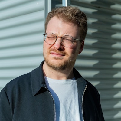 Maxi Gstettenbauer steht vor einer weißen Wand.