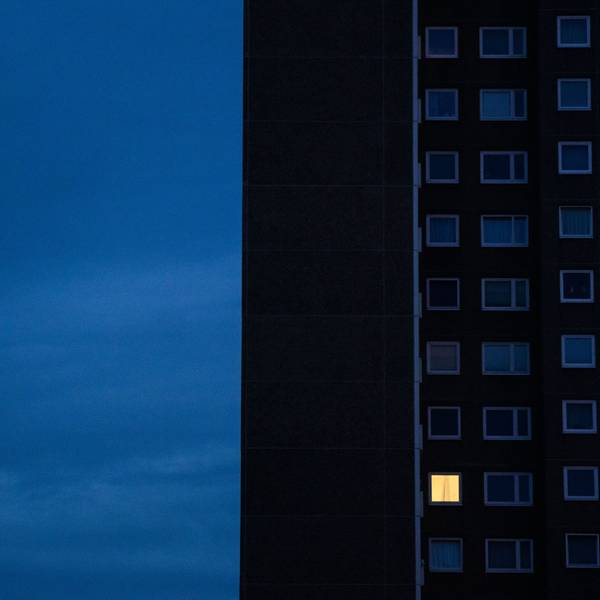 Nur in einer Wohnung eines Hochhauses brennt am frühen Morgen Licht.