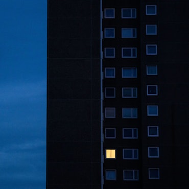 Nur in einer Wohnung eines Hochhauses brennt am frühen Morgen Licht.