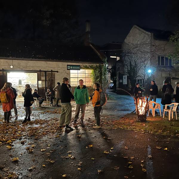 Anwohnerinnen und Anwohner stehen nachts im Innenhof des Petershof und genießen die Atmosphäre.