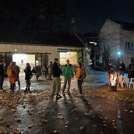 Anwohnerinnen und Anwohner stehen nachts im Innenhof des Petershof und genießen die Atmosphäre.