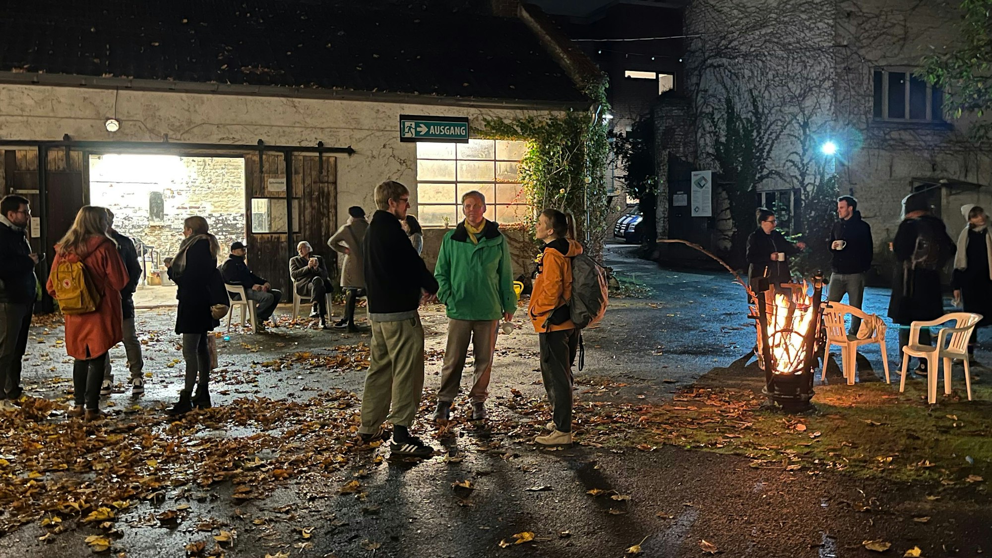 Anwohnerinnen und Anwohner stehen nachts im Innenhof des Petershof und genießen die Atmosphäre.