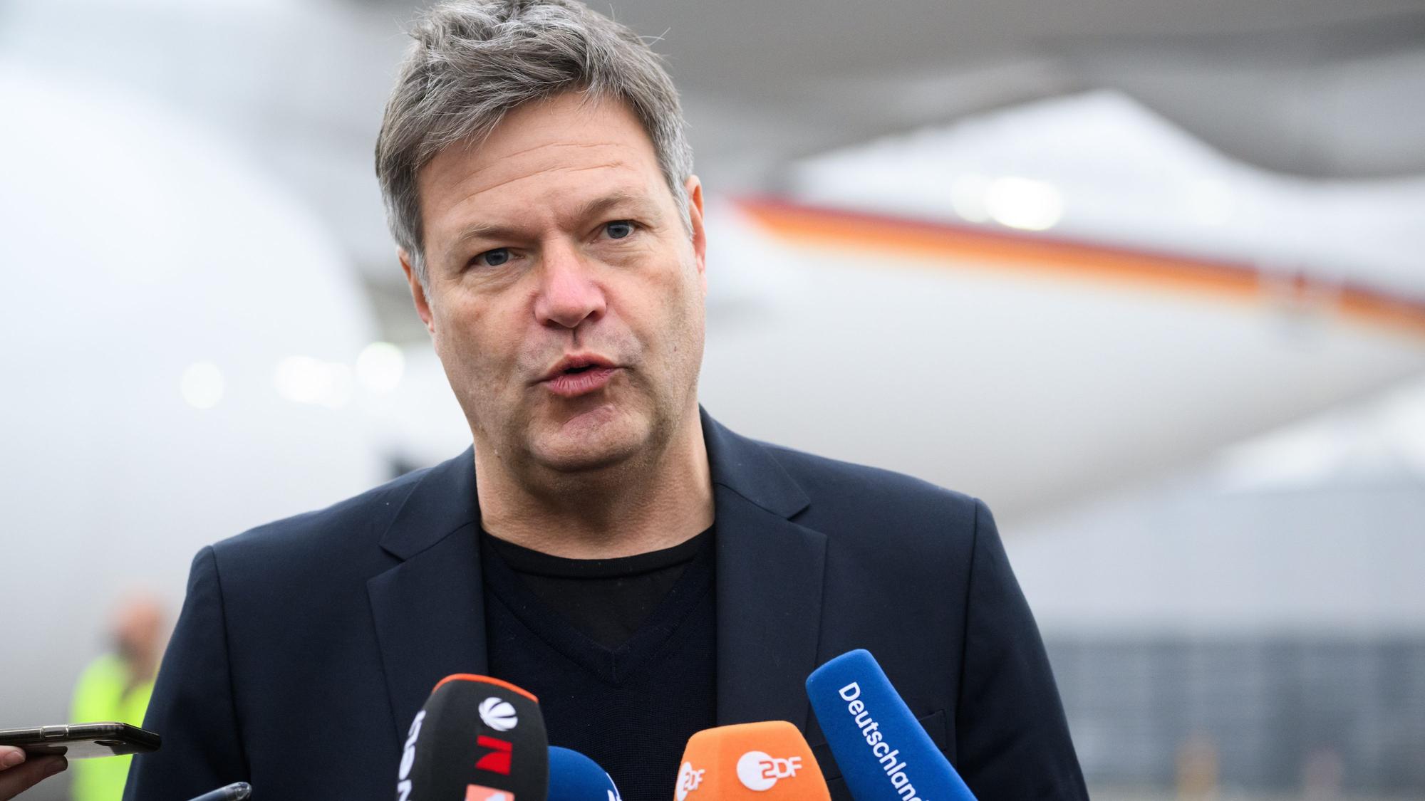 Bundeswirtschaftsminister Robert Habeck (Grüne) spricht in Mikrofone, er trägt ein blaues Sakko.