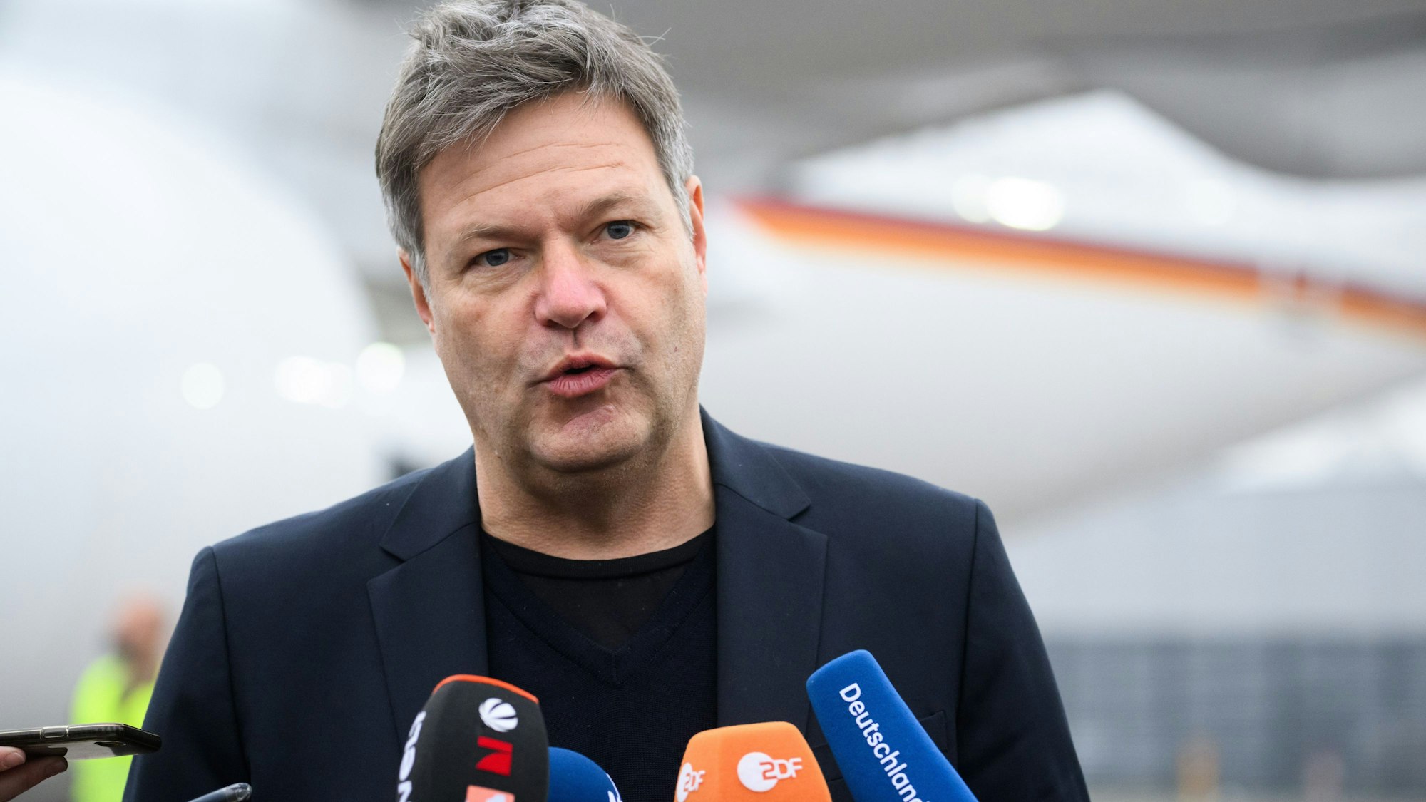 Bundeswirtschaftsminister Robert Habeck (Grüne) spricht in Mikrofone, er trägt ein blaues Sakko.