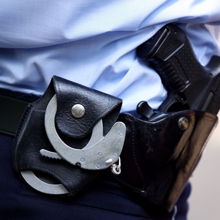Ein Polizist mit Handschellen und Pistole am Gürtel. (Symbolbild)