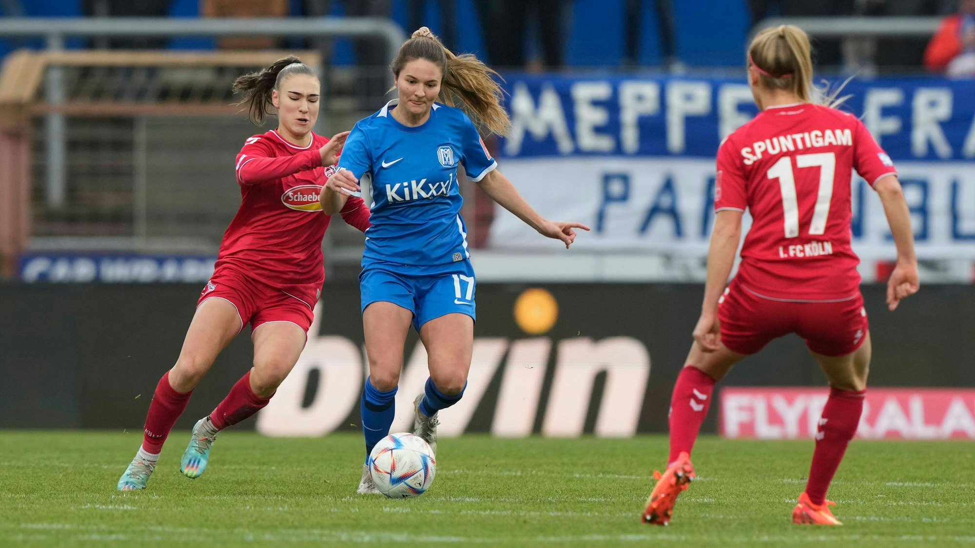 Eine Fußballspielerin läuft ihrer Gegnerin hinterher.