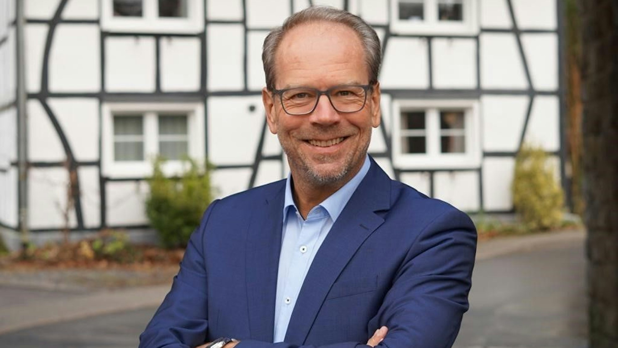 Bergheims Bürgermeister Volker Mießeler steht mit verschränkten Armen vor einem alten Gebäude in der Kreisstadt.