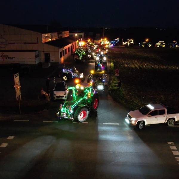 Mit Lichterketten geschmückte Traktoren fahren durch Wißkirchen.
