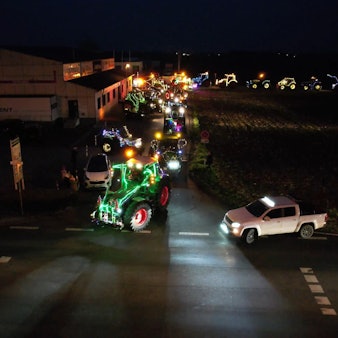 Mit Lichterketten geschmückte Traktoren fahren durch Wißkirchen.