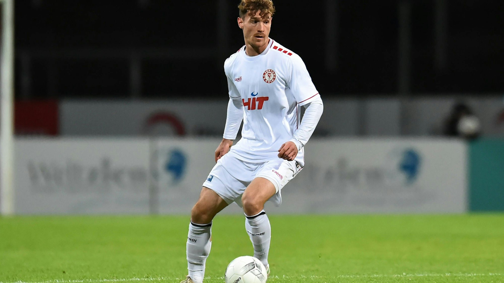 Porträt eines Fußballspielers, der den Ball mit dem linken Fuß führt.