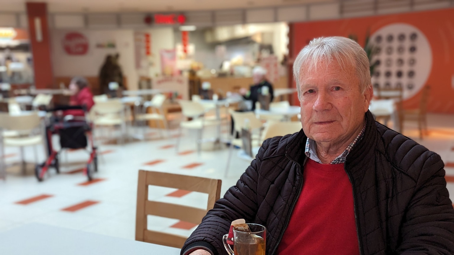 Leo. Fuß sitzt mit einem Tee auf einem Tablett an einem Tisch in einem Restaurant.