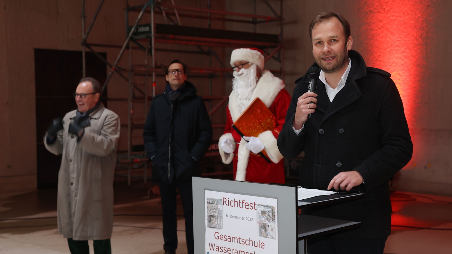 Dezernent Robert Voigtsberger
steht am Rednerpult, daneben der Nikolaus und zwei weitere Männer.