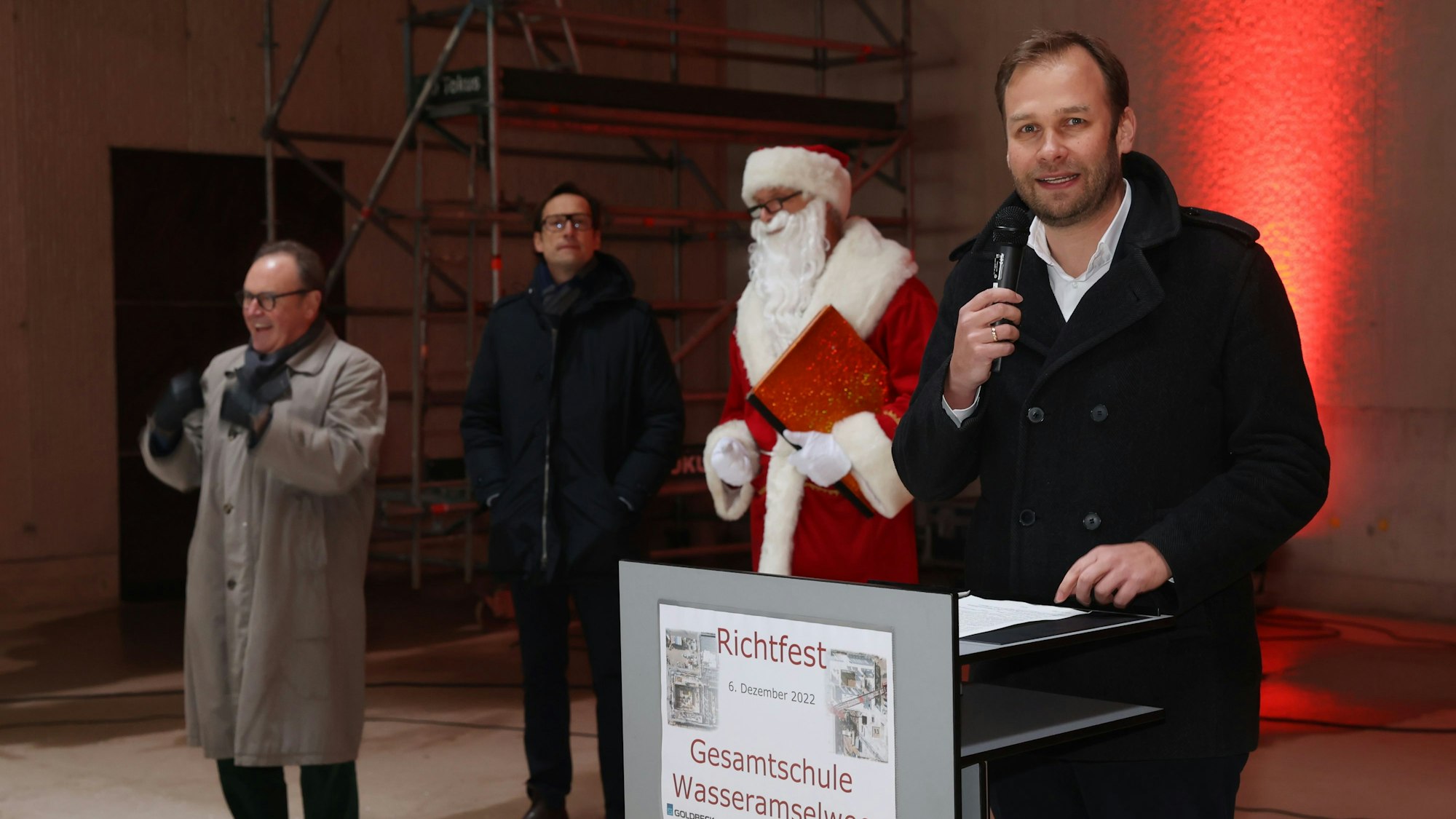 Dezernent Robert Voigtsberger
steht am Rednerpult, daneben der Nikolaus und zwei weitere Männer.