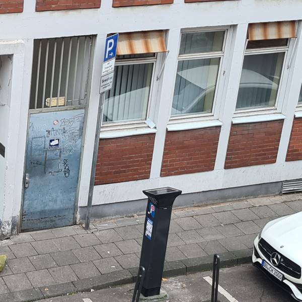 Ein abhängiger Mann sitzt in der Lungengasse vor der verschlossenen Tür des Drogenkonsumraums.