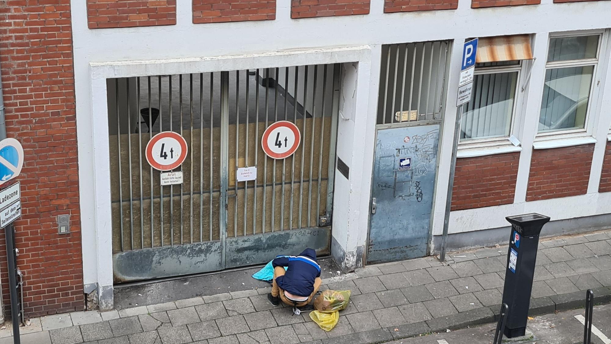 Ein abhängiger Mann sitzt in der Lungengasse vor der verschlossenen Tür des Drogenkonsumraums.
