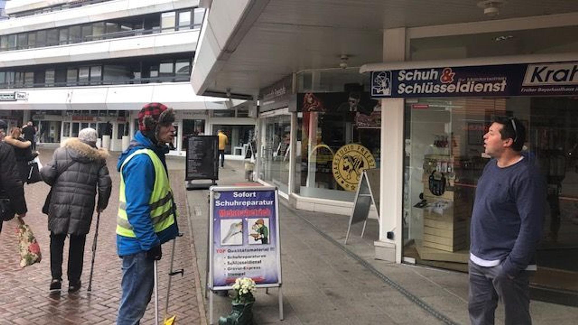 Passanten auf dem Friedrich-Ebert-Platz diskutieren den Stromausfall in Wiesdorf