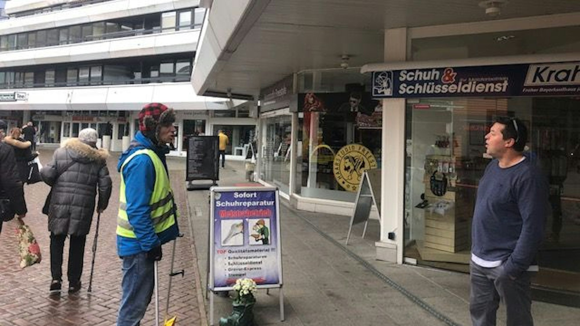 Passanten auf dem Friedrich-Ebert-Platz diskutieren den Stromausfall in Wiesdorf