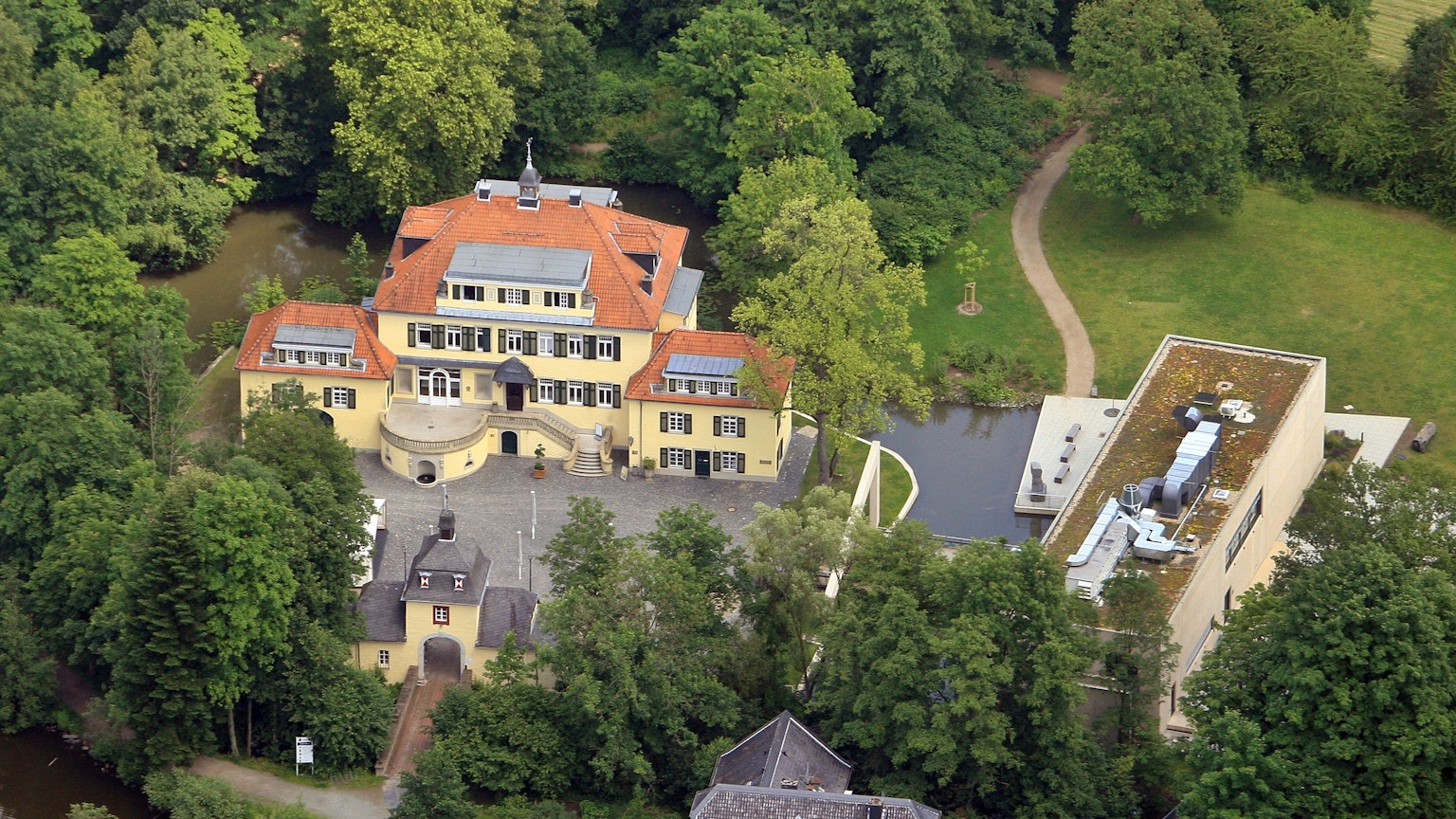 Ein Blick von oben auf Schloss Eulenbroich und das Werkstattgebäude.