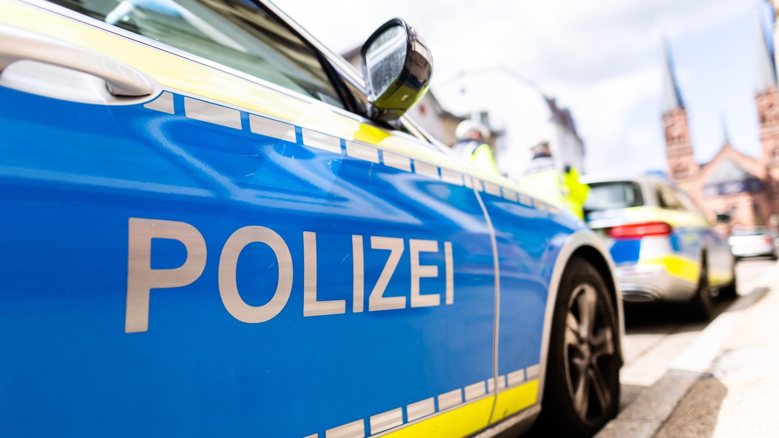 Zwei Einsatzfahrzeuge der Polizei stehen am Straßenrand.