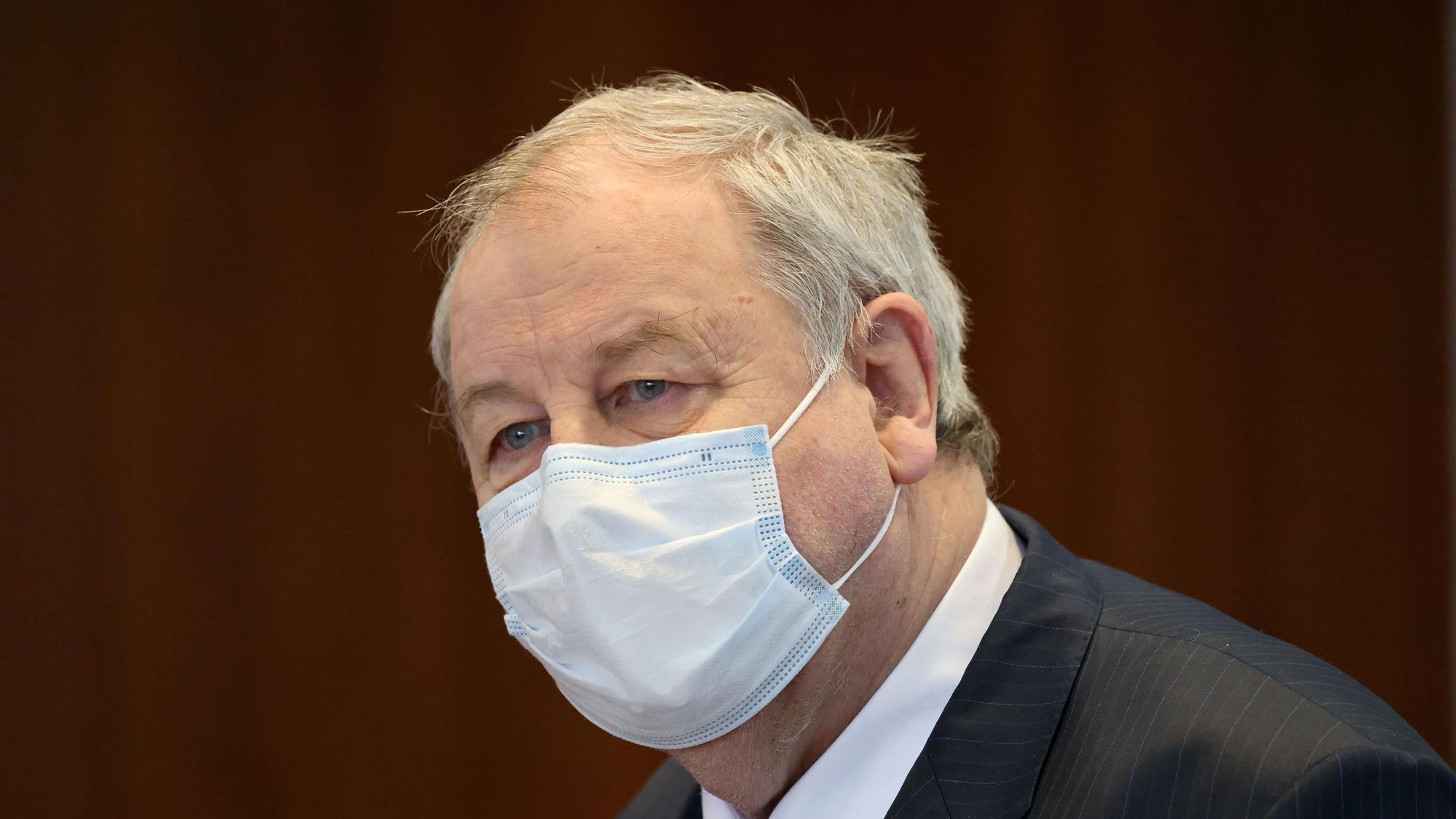 Hanno Berger, Angeklagter, steht im Gerichtssaal. Er trägt einen Mund-Nasen-Schutz und schaut an der Kamera vorbei.