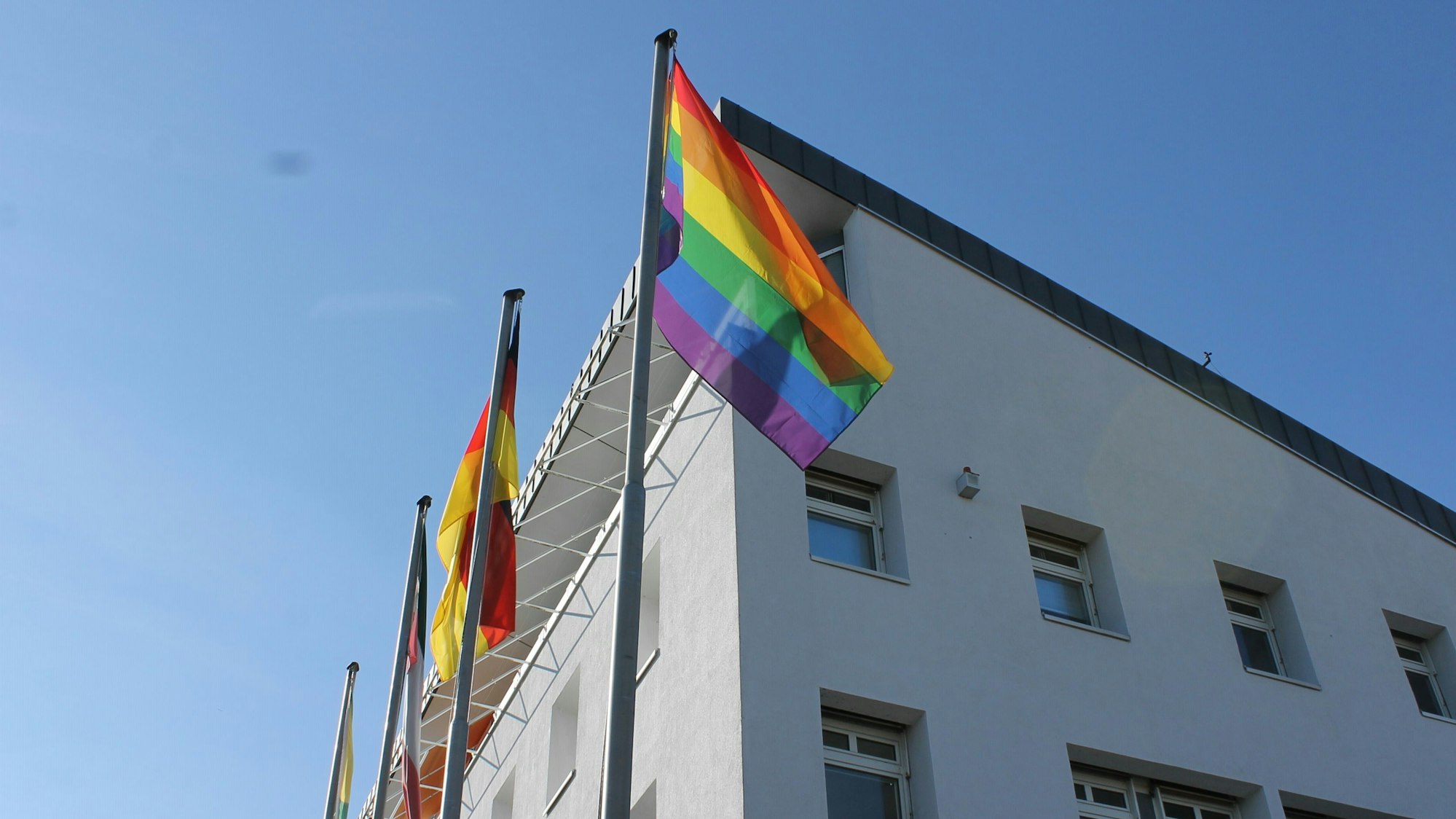 Das Erftstädter Rathaus. Davor wehen mehrere Regenbogenflaggen.
