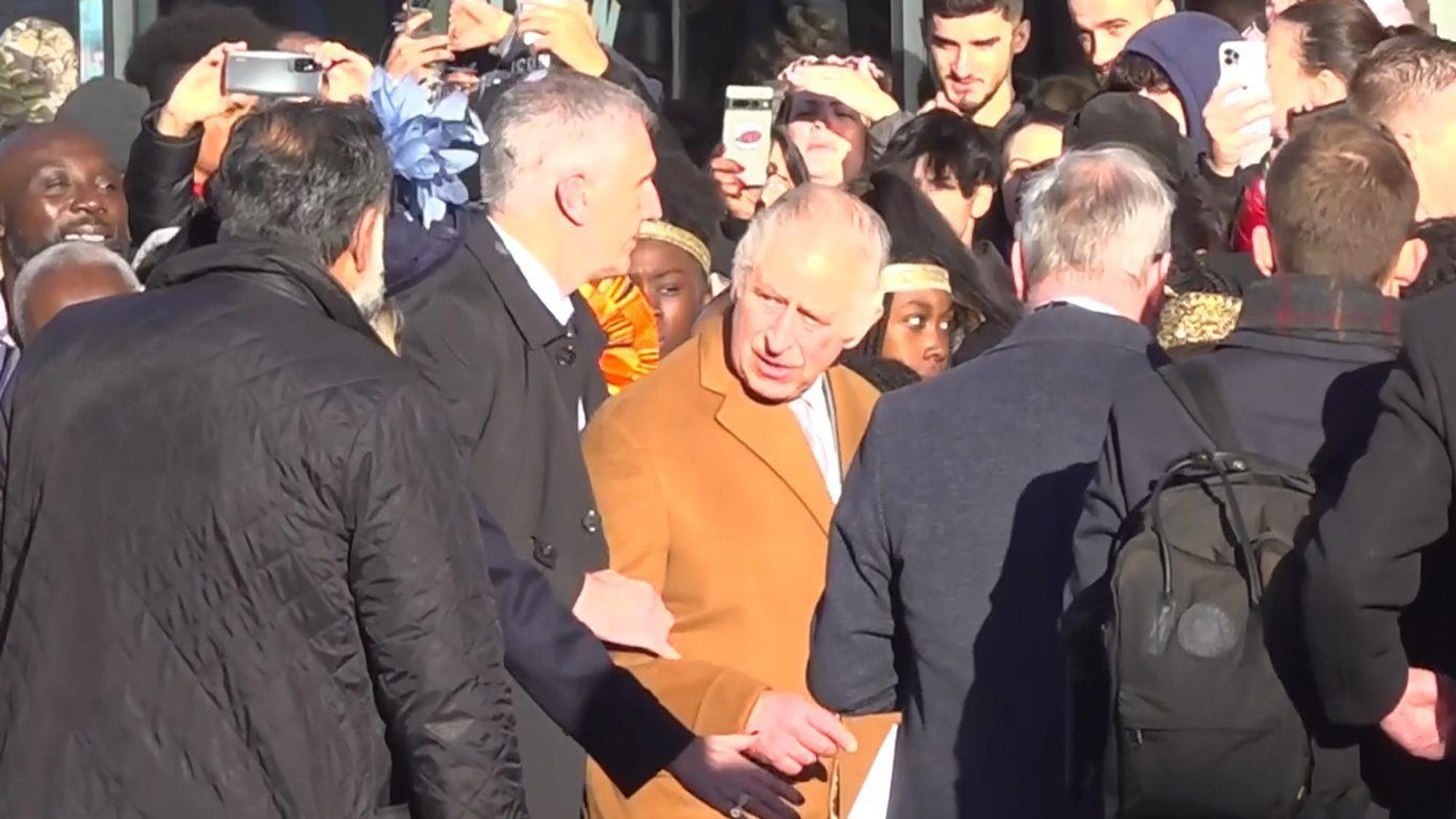 Das Bildschirmfoto aus einem PA-Video, zeigt, wie Sicherheitsbeamte König Charles III. von der Menge wegführen.