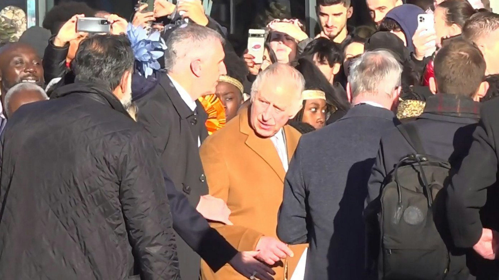 Das Bildschirmfoto aus einem PA-Video, zeigt, wie Sicherheitsbeamte König Charles III. von der Menge wegführen.