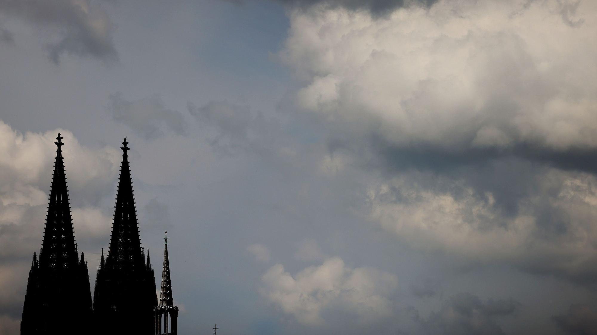 Wolken ziehen am dunklen Dom vorbei. Nur die Domspitzen sind zu sehen.