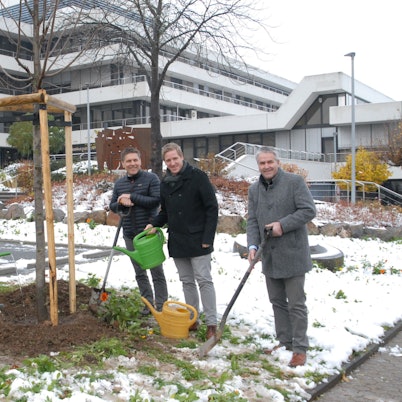 Mit Gießkannen und Spaten stehen Heike Schmitz (v.l.), Karl-Josef Schmitz, Stefan Dott, Markus Ramers und Markus Böhm an dem Baum, den sie gerade gepflanzt haben.