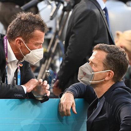 Die beiden deutschen Ex-Nationalspieler Lothar Matthäus (.l) und Oliver Bierhoff (r.) sprechen am Rand einer Tribüne miteinander.