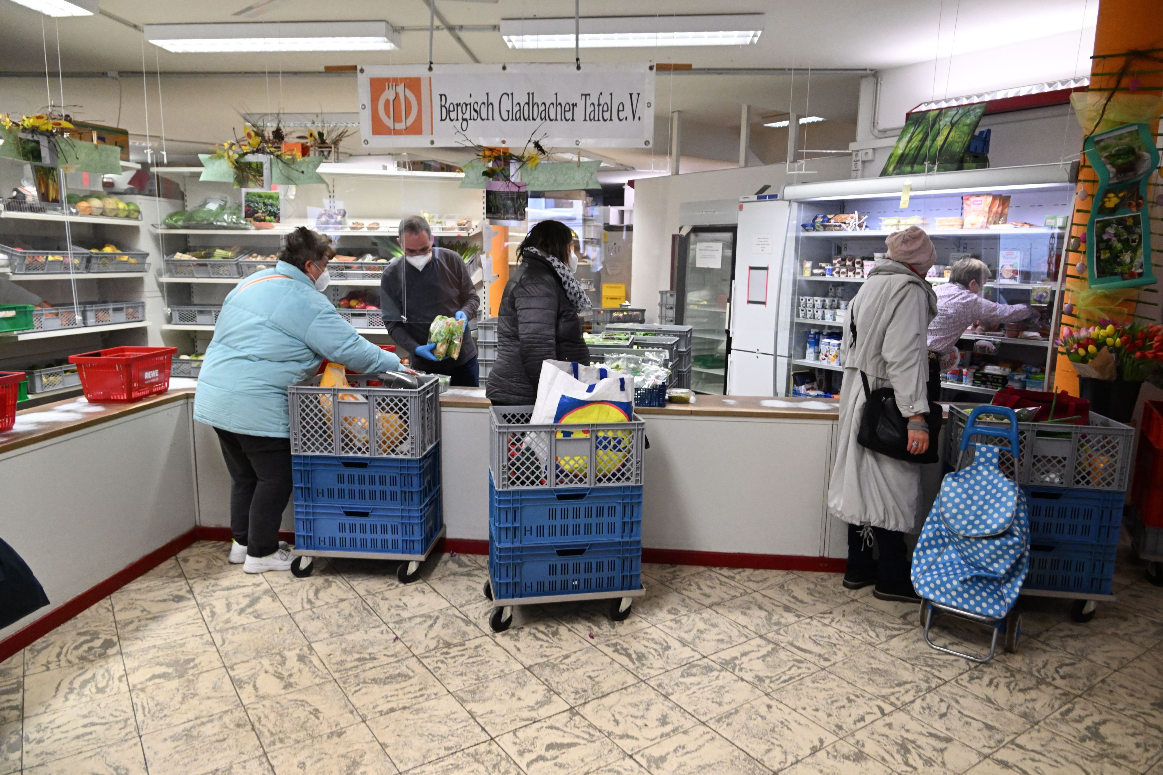 Mitarbeitende der Tafel Bergisch Gladbach geben Essen an die Kundschaft aus.