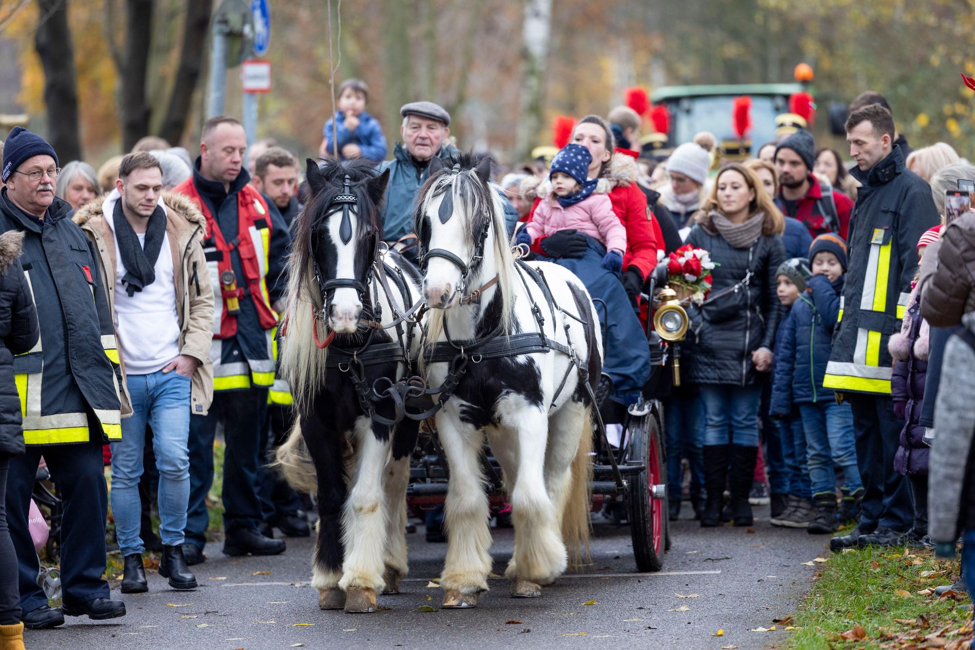 Nikolaus fährt mit einer Pferdekutsche durch eine Menschenmenge.