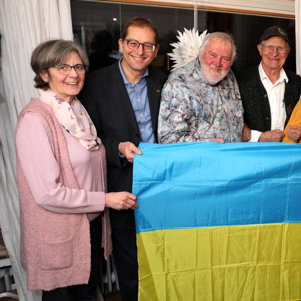 Beteiligte der Ukraine-Hilfe und der Bethe-Stiftung halten eine Ukraine-Flagge vor sich.