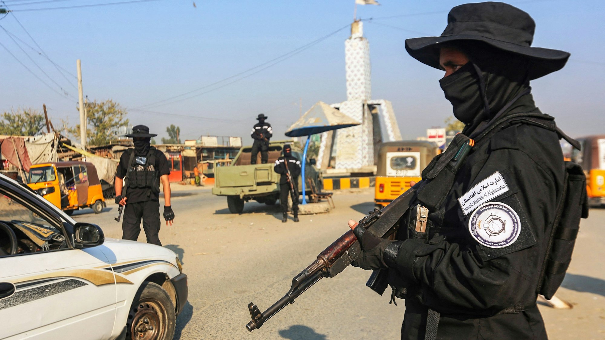 Ein Taliban mit einer Maschinenpistole steht an einem Checkpoint auf einer Straße in der Stadt Jalalabad