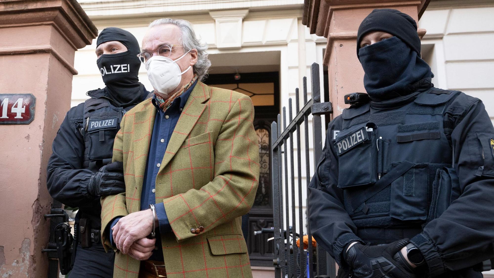 Bei einer Razzia gegen sogenannte Reichsbürger führen vermummte Polizisten, nach der Durchsuchung eines Hauses Heinrich XIII Prinz Reuß (2.v.r.) in Handschellen raus.