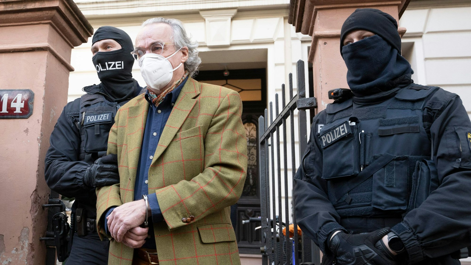 Bei einer Razzia gegen sogenannte Reichsbürger führen vermummte Polizisten, nach der Durchsuchung eines Hauses Heinrich XIII Prinz Reuß (2.v.r.) in Handschellen raus.
