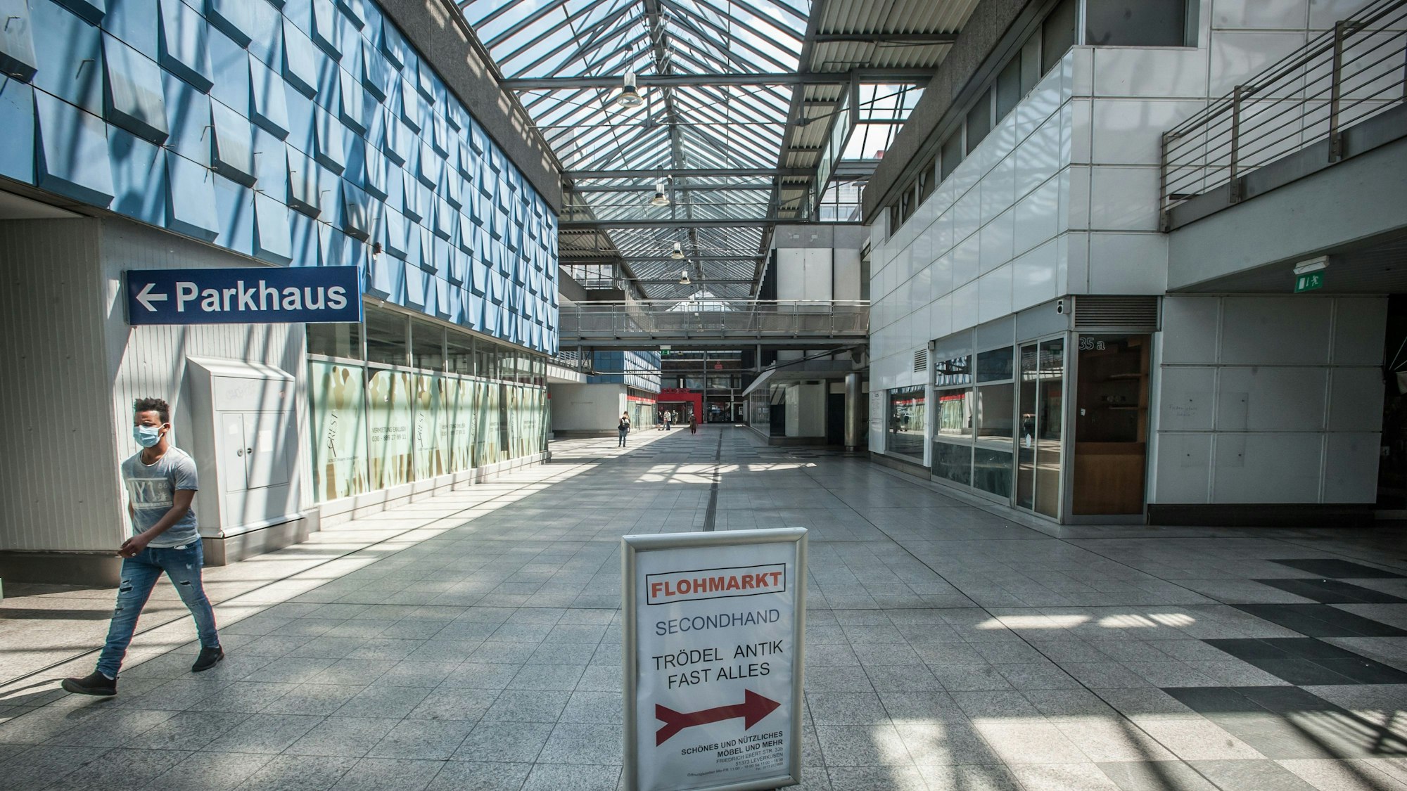 Blick in den weitgehend verlassenen Boulevard der City C. Links geht ein Mann aus dem Bild.